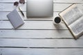 Overhead shot of an open bible near a coffee and, laptob, notepad with a pen Royalty Free Stock Photo