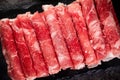 Overhead shot of a pile of thinly sliced rolled raw meat for hot pot