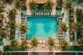 An overhead shot of a poolside lounge area with palm trees, cabanas, and people relaxing in stylish swimsuits, evoking the