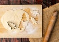 Overhead shot of raw dough and Christmas cookie cutter on rustic kitchen table Royalty Free Stock Photo