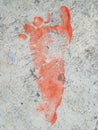 Overhead shot of a red footprint painted on the ground