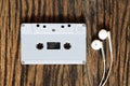 Overhead shot of retro old audio cassette tape with earphone on grunge vintage wood background, top view Royalty Free Stock Photo