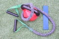 Overhead shot of round heavy weight, stretchy gym equipment and blue resistance band on grass