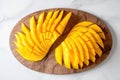 an overhead shot of sliced mango on a marble board