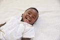 Overhead Shot Of Smiling Young Boy Lying On Bed