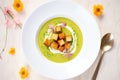 overhead shot of split pea soup with croutons and cream swirl