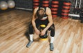 Overhead shot of sporty man sitting on sandbag relaxing after exercises in the gym. Attractive athletic male rest after hard