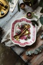 Overhead shot of vintage plate with pink ornament with brass spoons, strainers and chiness tea Royalty Free Stock Photo