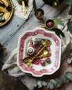 Overhead shot of vintage plate with pink ornament with brass spoons, strainers and chiness tea Royalty Free Stock Photo