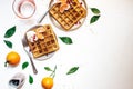 Overhead shot of waffles with orange slices on a white plate near forks Royalty Free Stock Photo