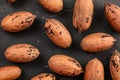 Overhead shot, whole pecan nuts in shell on black board