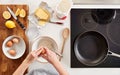 Overhead Shot Of Woman In Kitchen With Ingredients Making Pancakes Or Crepes For Pancake Day