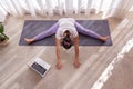 young woman practices yoga class online