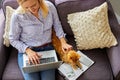 Overhead Shot Of Woman Working From Home On Laptop Sitting On Sofa During Lockdown Stroking Pet Cat Royalty Free Stock Photo