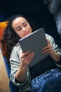 Overhead Shot Of Young Woman Relaxing At Home Lying On Sofa Reading Book On Digital Tablet Royalty Free Stock Photo