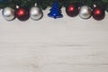 Overhead top view of colorful Christmas ornaments hanging on a fir branch on a wooden background