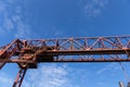 Overhead trusses, catwalks, and stairs of a massive industrial structure against a deep blue sky