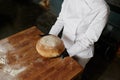 Overhead view on baker hand in gloves presenting freshly baked bread