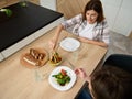 Overhead view of a beautiful young pregnant woman, attentive wife serving her husband a vegetable salad. Happy Caucasian couple Royalty Free Stock Photo