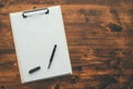 Overhead view of blank clipboard note pad paper with pen Royalty Free Stock Photo