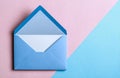 Overhead view of a blue envelope that is open, revealing a blank paper sheet inside, positioned on a pale blue Royalty Free Stock Photo