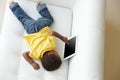 Overhead View Of Boy On Sofa Playing With Digital Tablet