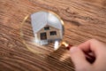 Person Holding Magnifying Glass Over House Model Royalty Free Stock Photo
