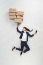 overhead view of businesswoman with smartphone holding pile of cardboard boxes