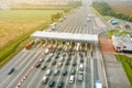 An overhead view of a busy toll road with many cars queuing up to pay the highway toll