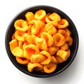 Overhead view of cheese puffs in a dark bowl on a white surface Royalty Free Stock Photo