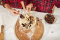 Overhead view of children`s hands sprinkling ready-made dough in bowl with dried fruits and nuts, preparing dough for Christmas Royalty Free Stock Photo