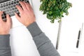 overhead view of clean white office desk with person typing on laptop computer Royalty Free Stock Photo