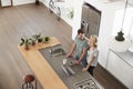 Overhead View Of Couple Looking At Laptop In Modern Kitchen