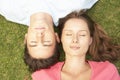 Overhead View Of Couple Lying On Grass With Eyes Closed Royalty Free Stock Photo