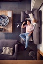 Overhead View Of Couple Relaxing On Lounge Sofa Having  Afternoon Nap At Home And Watching TV Royalty Free Stock Photo