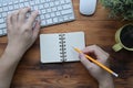 Creative man holding pencil making note on notebook.