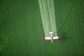 A crop duster spraying a green farm field. Royalty Free Stock Photo
