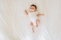 overhead view of cute newborn baby in white bodysuit lying