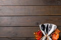 Overhead view of cutlery, rustic string napkin with autumn leaves, copy space on wooden background