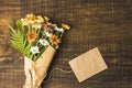 overhead view delicate flower bunch brown paper tag wooden surface. High quality photo