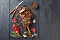 Overhead view of delicious roast tender leg of lamb served with pomegranate seeds, mint leaves, spices and rosemary on a black Royalty Free Stock Photo