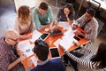 Overhead View Of Designers Having Meeting Around Table