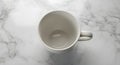 Overhead view of an empty white mug on a bright marble surface, minimalist composition Royalty Free Stock Photo
