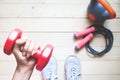 Overhead view of fitness girl holding red dumbbell with fitness equipments on wooden floor. Healthy and Diet Royalty Free Stock Photo