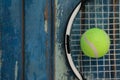 Overhead view of fluorescent yellow tennis ball on racket