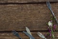 Fork, butter knife and spoon with flower on wooden table Royalty Free Stock Photo