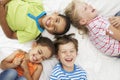 Overhead View Of Four Children Playing On Bed Together