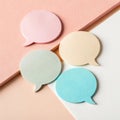 Overhead view of four pastel speech bubble sticky notes arranged on a textured surface Royalty Free Stock Photo
