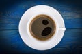 Overhead view of a freshly brewed mug of espresso coffee on blue rustic wooden background with woodgrain texture. Coffee break Royalty Free Stock Photo