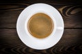 Overhead view of a freshly brewed mug of espresso coffee on rustic wooden background with woodgrain texture. Coffee break style. Royalty Free Stock Photo